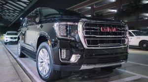 2025 GMC YUKON XL SLT black on black in the pick up drop off limo lane at SAV Savannah Hilton Head International Airport with captain's chairs in the second row luxury suv chauffeur service